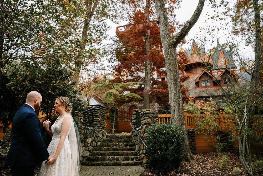 Bride & Groom holding hands in an autumn setting in front of Landoll's Mohican Castle